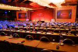Vast upscale brand event in a theatre with many viewing seats and large signage on stage