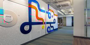 Office hallway adorned with a dimensional mural depicting a company timeline.